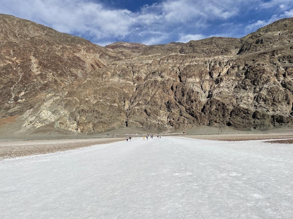 Badwater Basin with people walking on salt flat with mountains in the background at Death Valley National Park