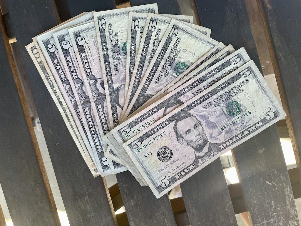 A five dollar bills on a picnic table