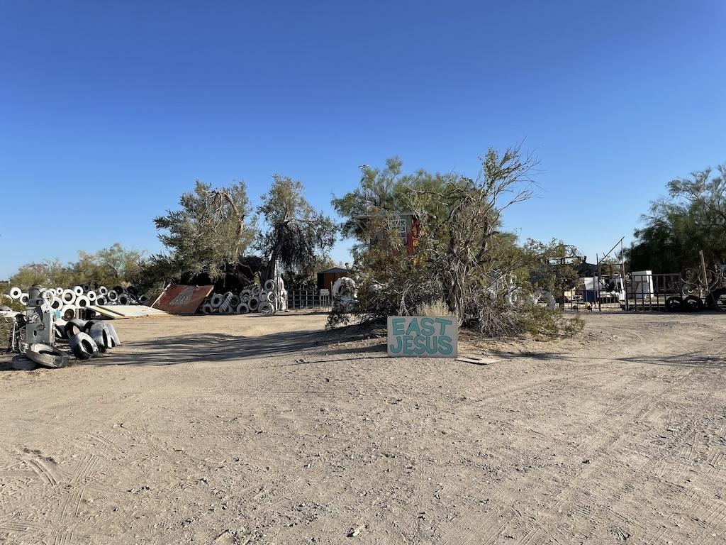 East Jesus sign at Slab City in a middle of a dirt road that splits