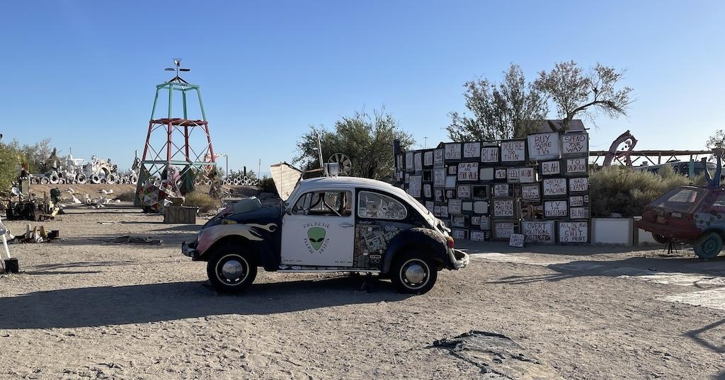 We saw lots of political signs behind a car installation in East Jesus while visiting Slab City
