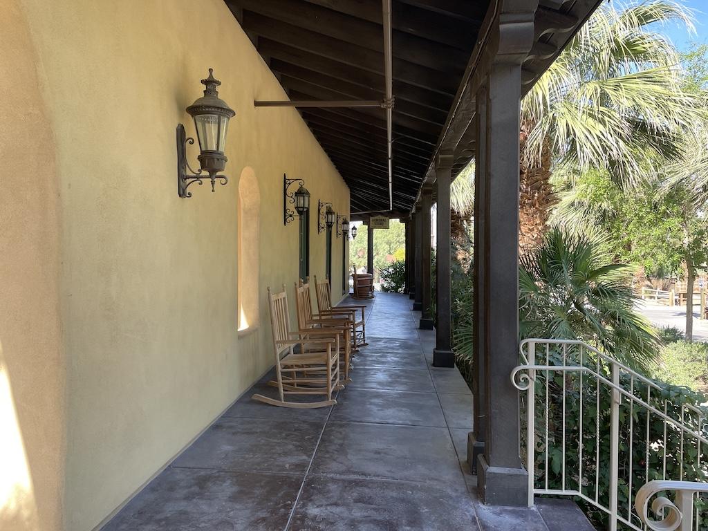 Outside hallway leading to General Store at the Ranch in Death Valley with rocking chairs and western themed decor outside