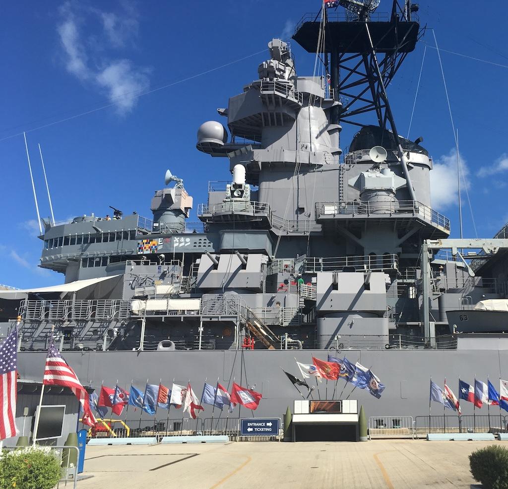 Front view of the Battleship Missouri Memorial with flags in front and entrance, near Pearl Harbor in Oahu, Hawaii