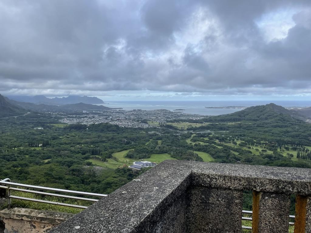 Coastline view from cliff at Nu'uanu Pali Lookout in Ohau, with lush forest, trees, mountains, and the Pacific ocean 