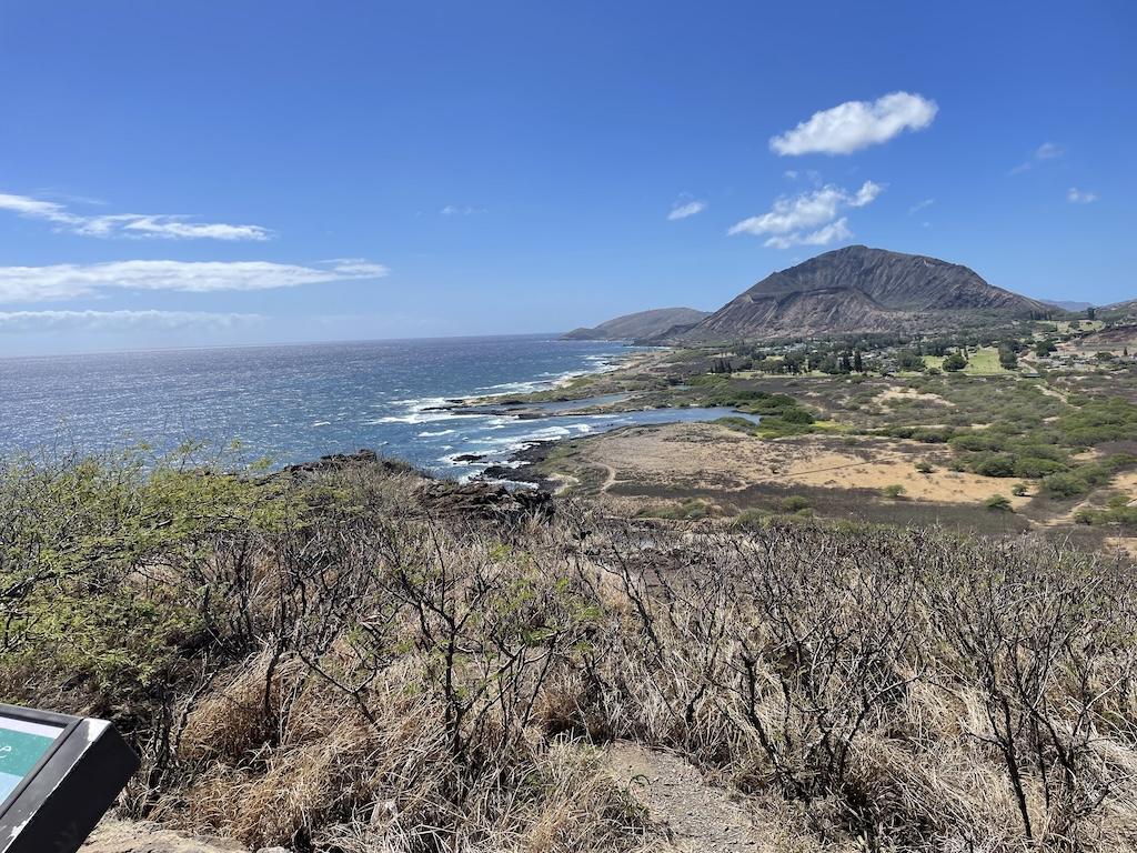 View of Koko Crater in the distance while walking the trail at the Makapu’u Lighthouse hike in Oahu, Hawaii with view of ocean