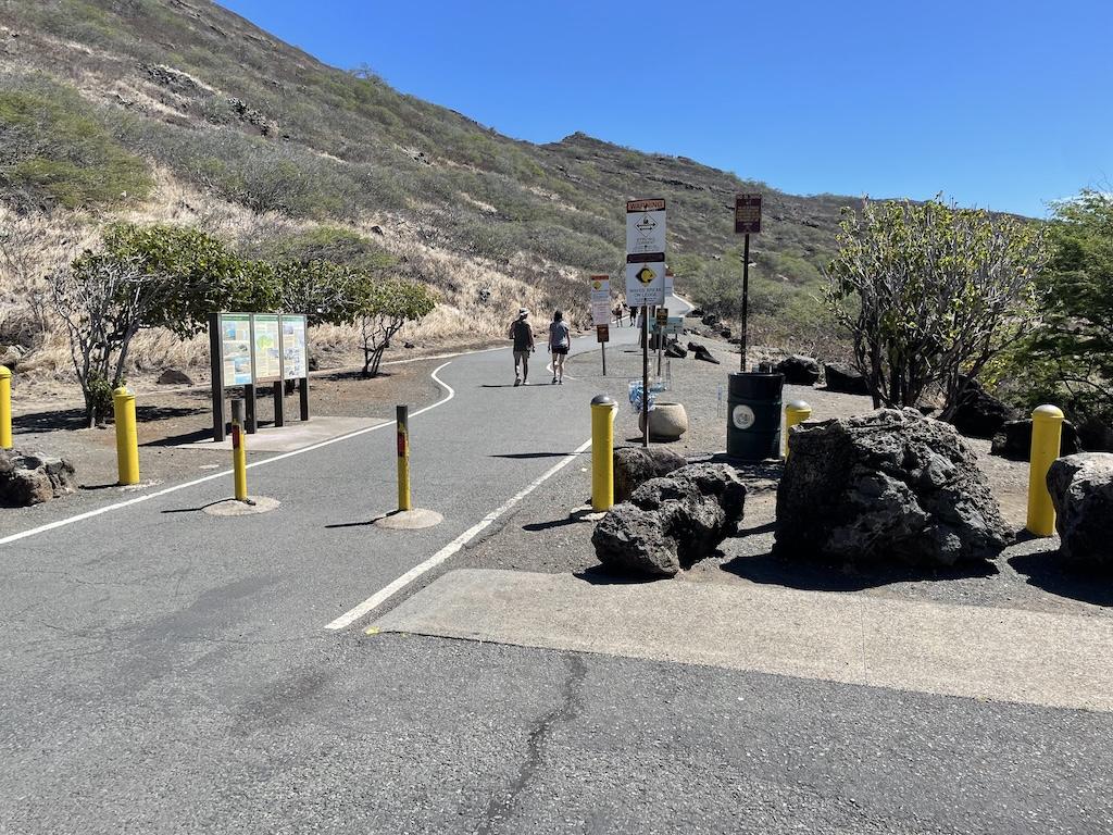People in the distance walking down the trail at the Makapu’u Lighthouse hike trailhead in Oahu, Hawaii