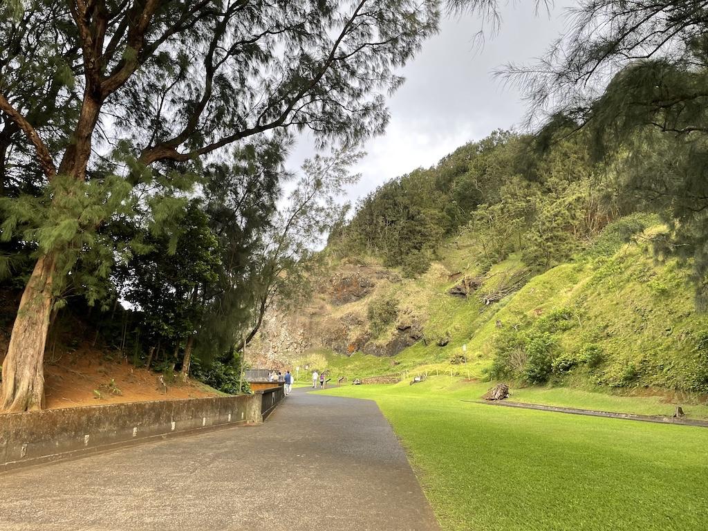 People in the far distance walking on the path from the parking lot leading to Nu'uanu Pali Lookout in Ohau, Hawaii