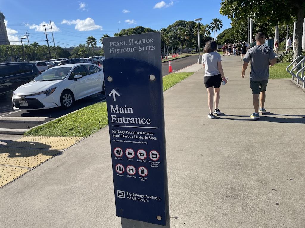People visiting Pearl Harbor and pointing to entrance, Oahu, Hawaii