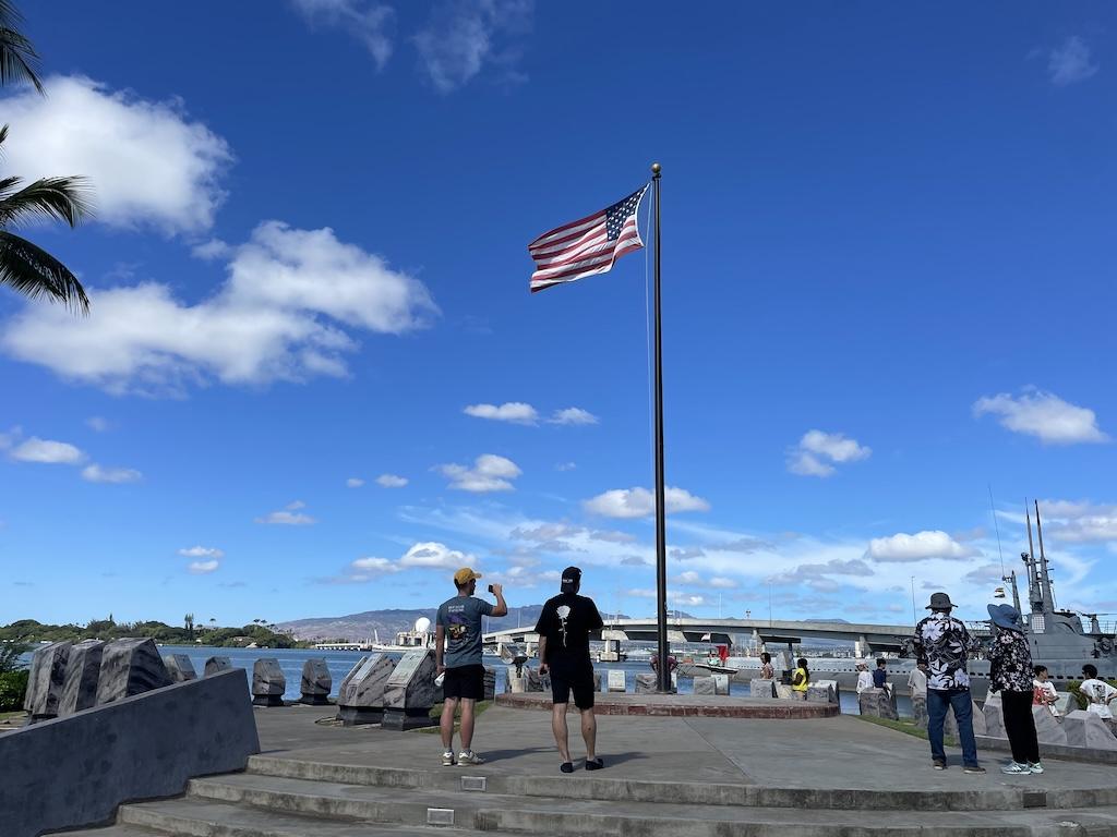 People looking at the flag while visiting the Pearl Harbor Memorial in Oahu, Hawaii