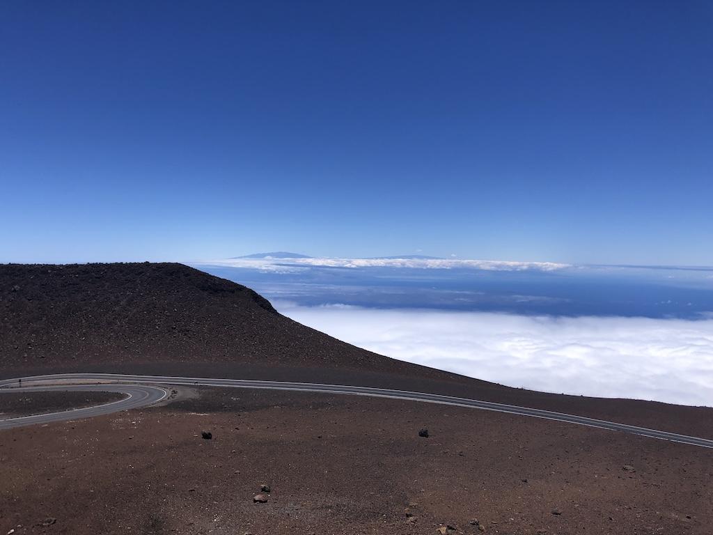 Winding roads in the distance with blue sky and clouds at Haleakala National Park in Maui, Hawaii