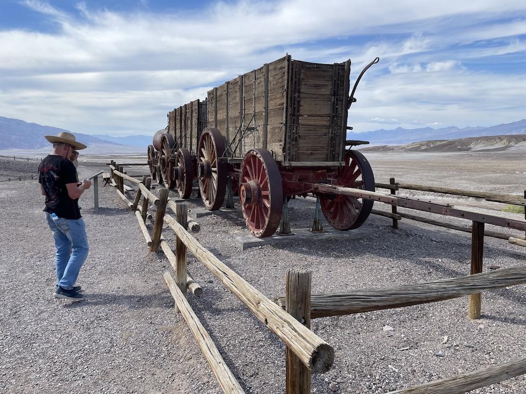 People looking at an old wagon at Harmony Borax Works at Death Valley National Park in California