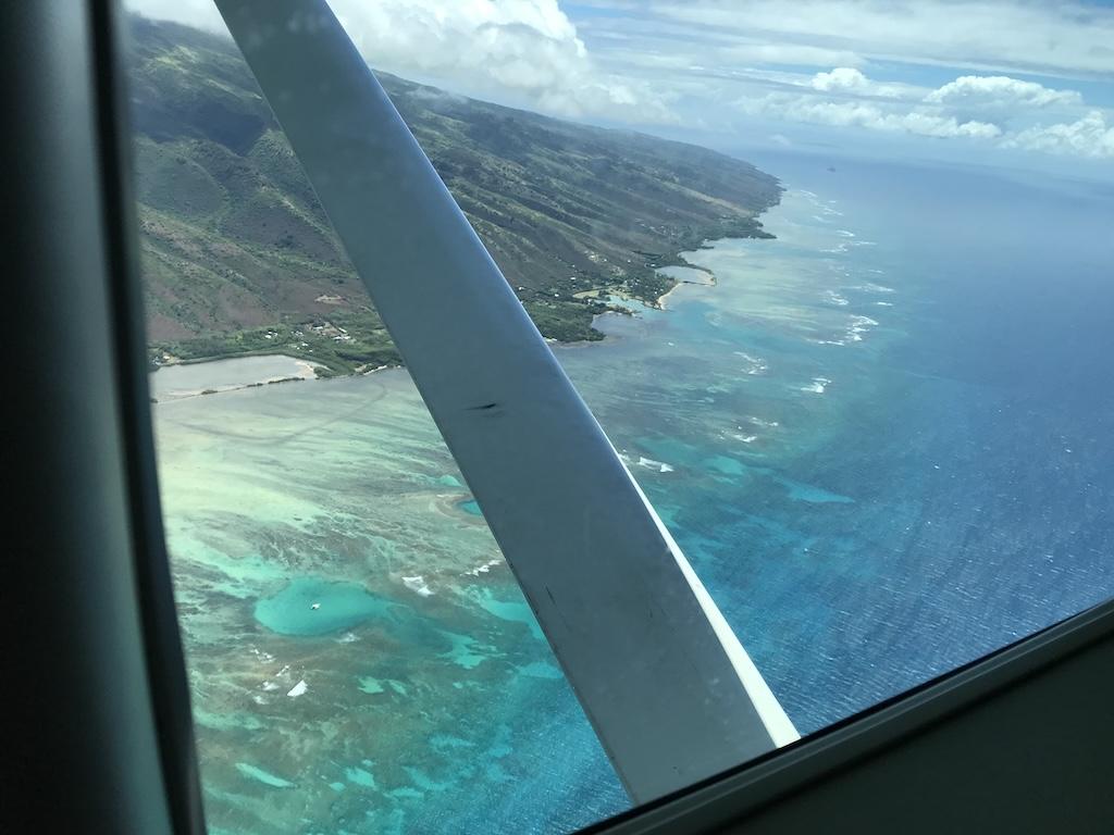 View of Hawaii from flying from Honolulu to Maui in a small jet over the Pacific Ocean and blue-green waters