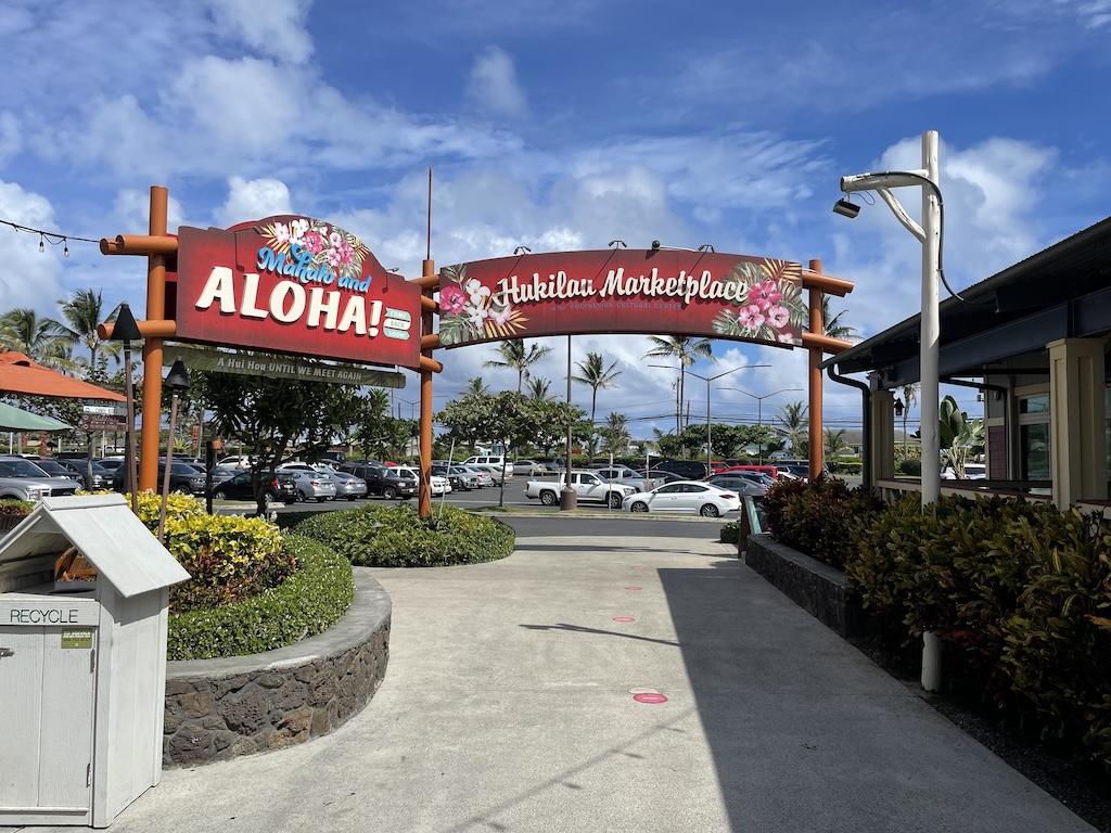 Hukilau Marketplace signage and the background of the parking lot at the Polynesian Cultural Center in Oahu, Hawaii