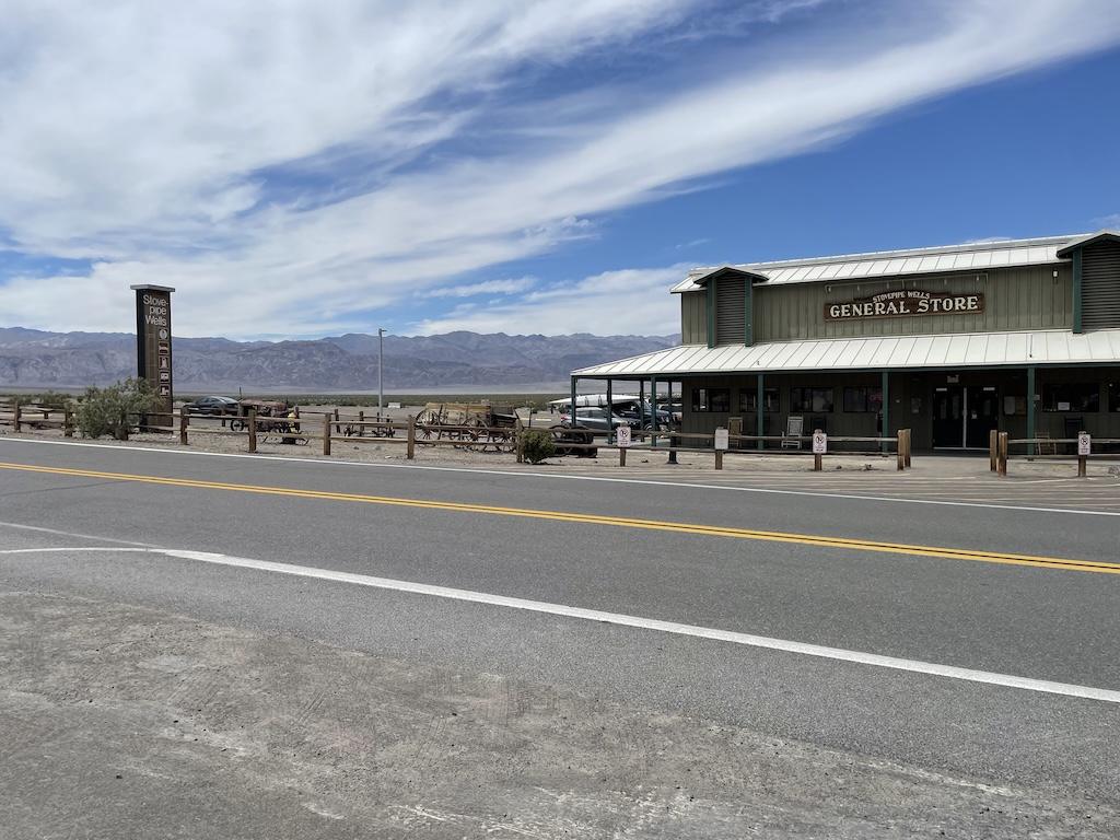 Stove Pipe Wells General Store from across the street and old western wagons in the distance