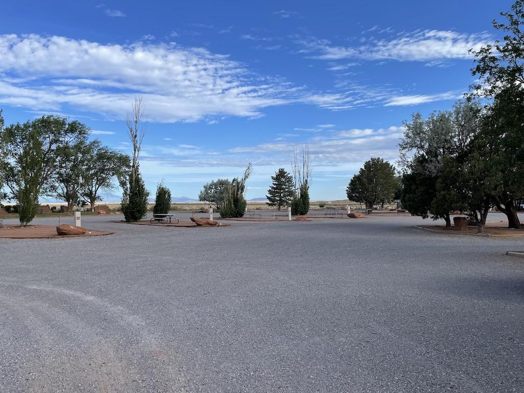 Empty camping spaces with trees at Meteor Crater RV Park, located in Winslow, Arizona