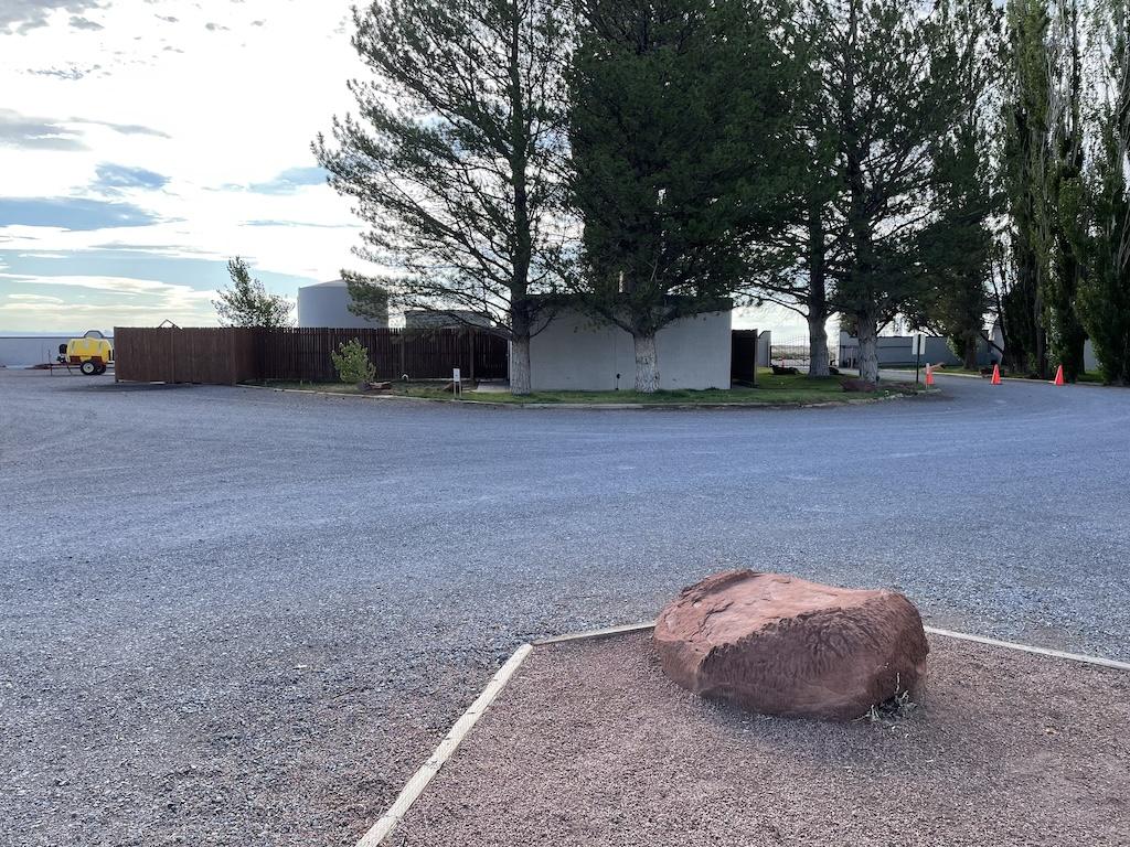 Big red rock and facilities with tress, at Meteor Crater RV Park, in Winslow, Arizona.