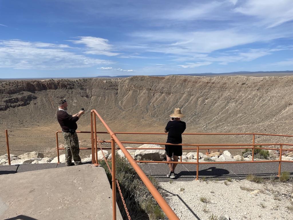 People taking pictures while visiting Meteor Crater while on the walking path, in Winslow, Arizona