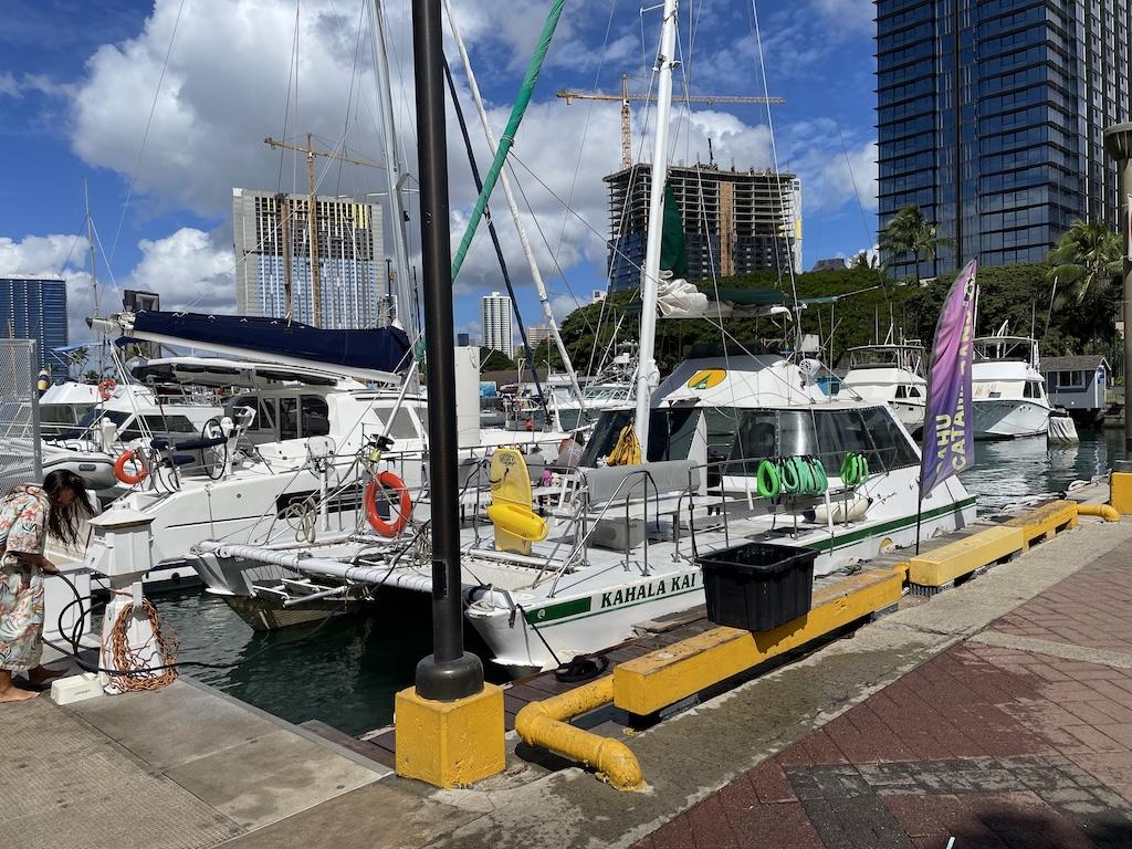 View of Kahala Kai catamaran used by Oahu Catamarans docked at Kewalo Basin boat harbor at Pier A in Honolulu, Hawaii.