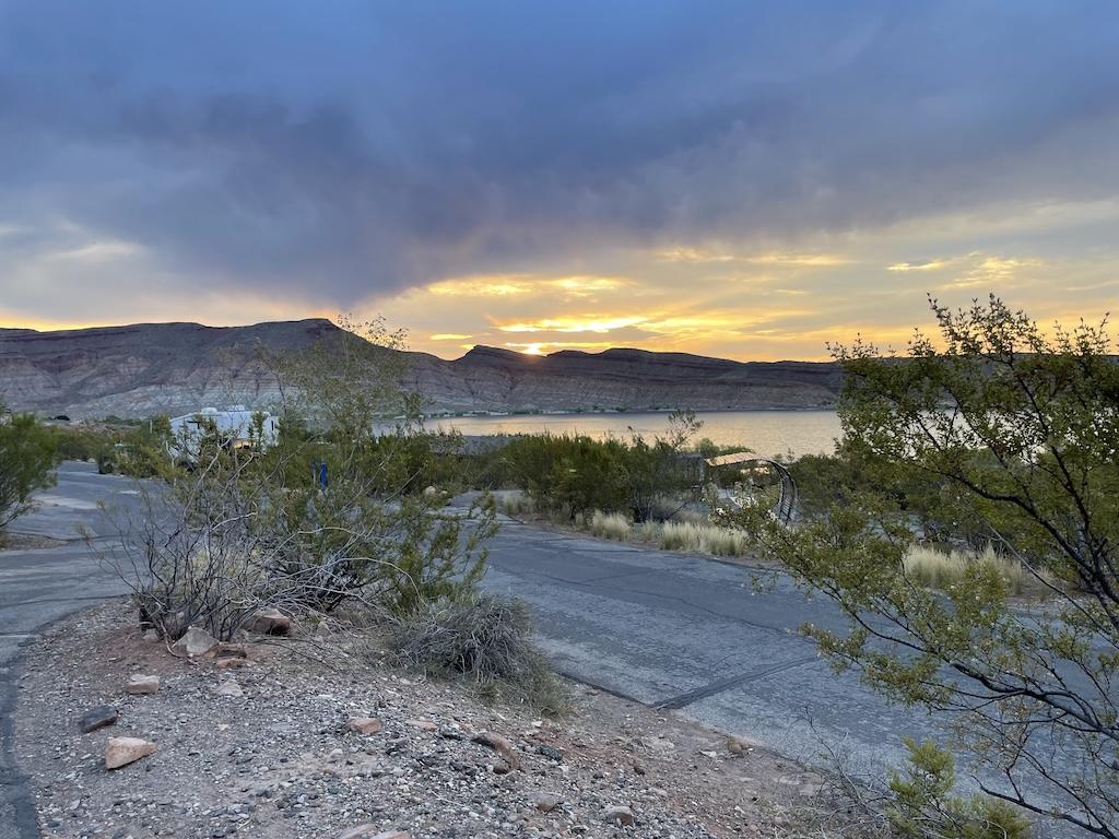 Sunrise at while camping at Quail Creek State Park Campground in Hurricane, Utah, with dark clouds and light peaking over the mountains 