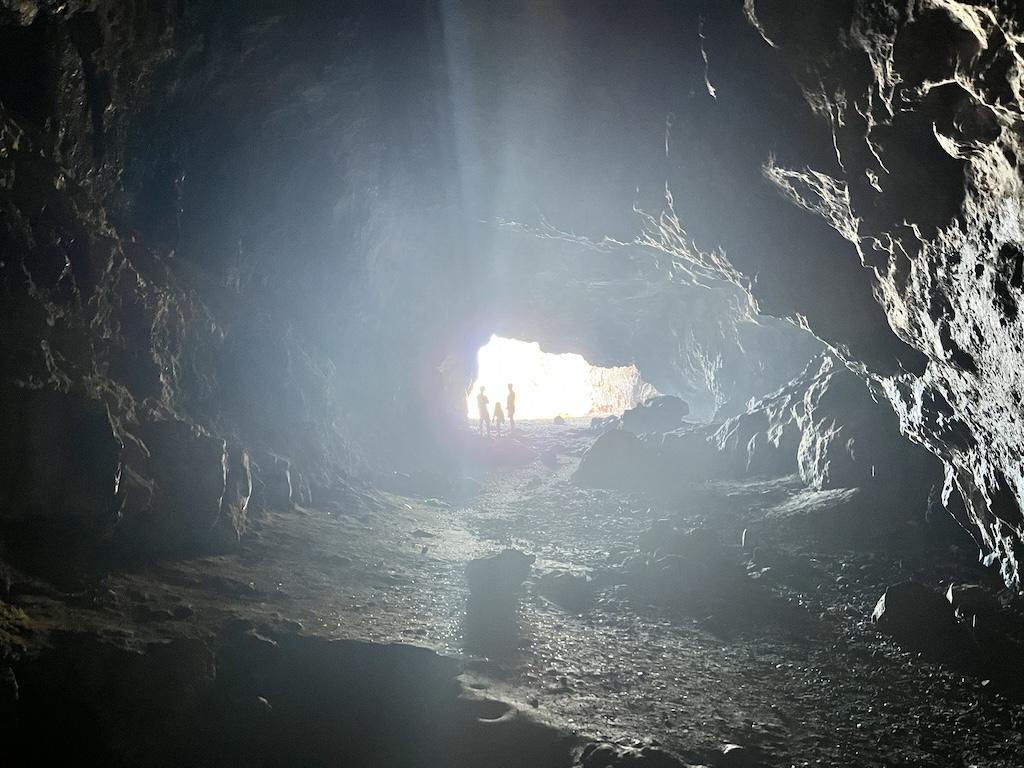 People at the opening of the Kaneana Cave in Ka’ena Point State Park in Oahu, Hawaii