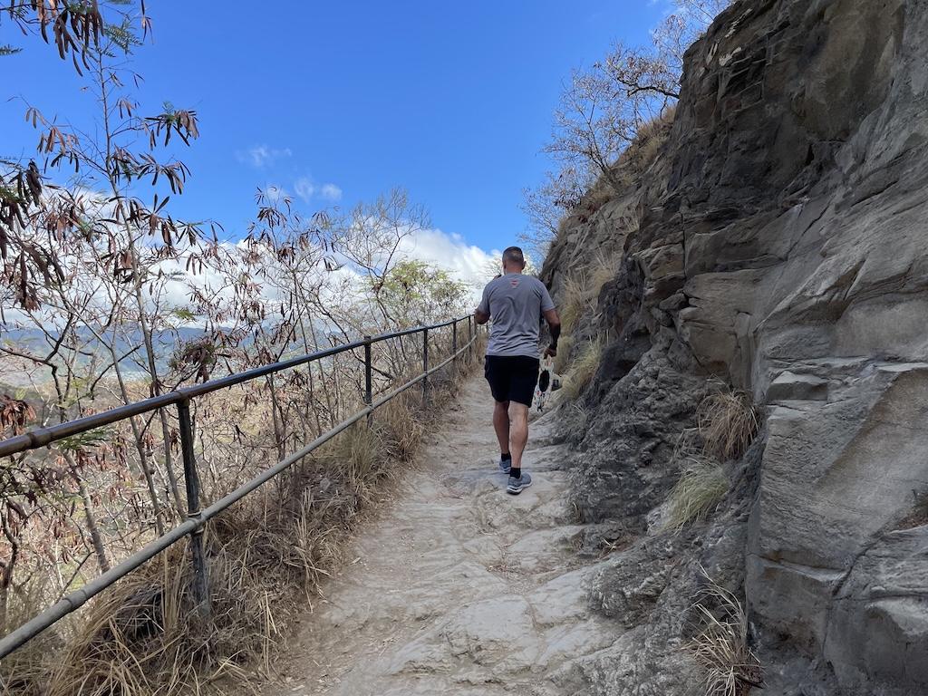 Man hiking up steep, uneven trail at the Diamond Head State Monument in Oahu, Hawaii