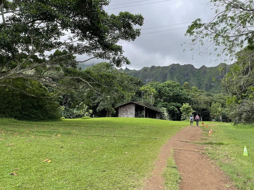 Ho’omaluhia Botanical Garden lake trail leading from the visitor center to the lake with people walking in the distance, in Oahu, Hawaii