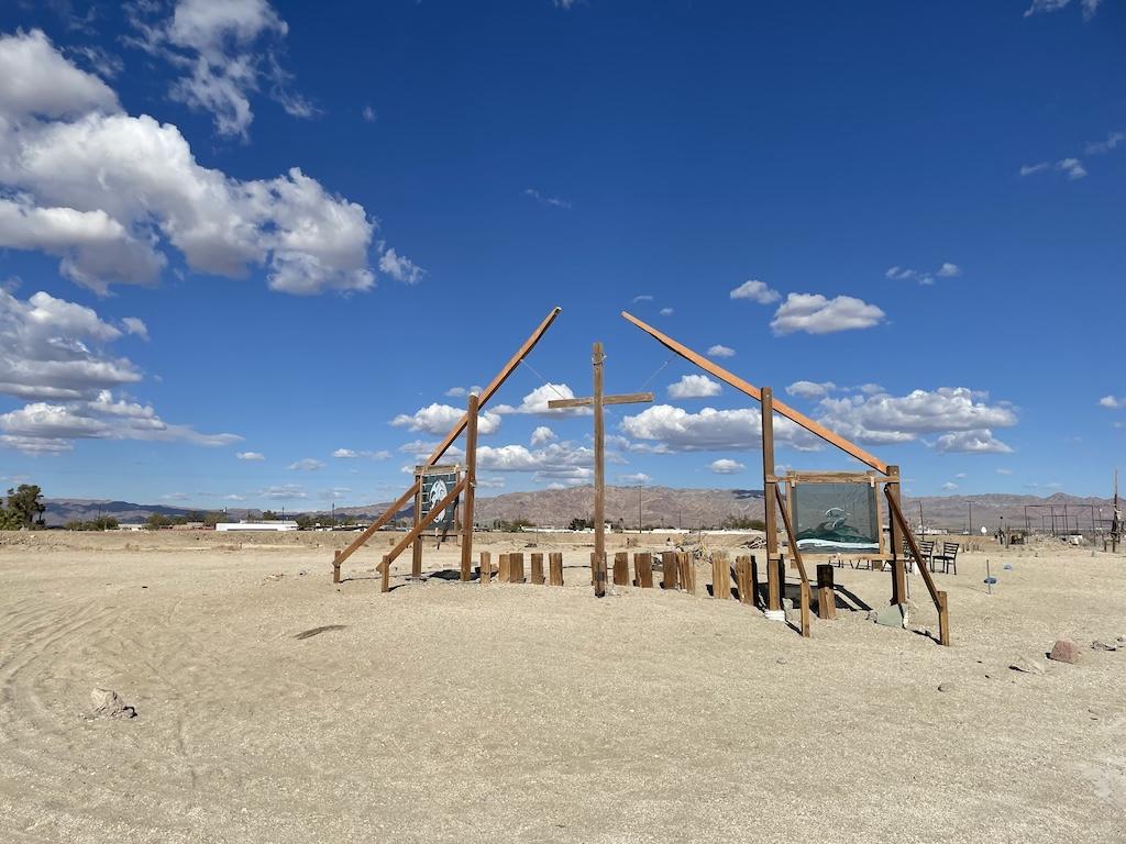 Exhibit made out of wood with paintings and a big cross Luna saw while visiting Bombay Beach on the Salton Sea in California
