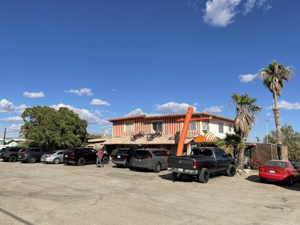 Restaurant with a colorful building and cars parked outside at Bombay Beach on the Salton Sea in California