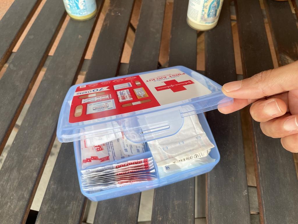 Luna’s hand opening the first aid kit that she uses while traveling in her van