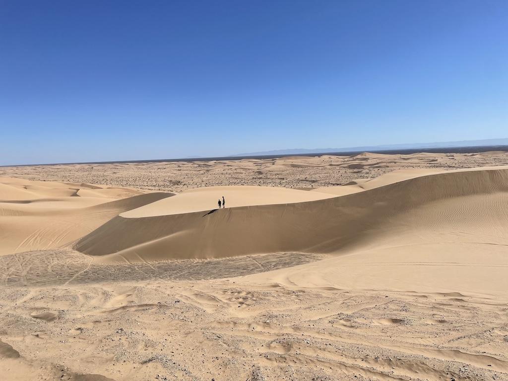 People in the far distance walking in the sand dunes at Hugh T. Osborne Lookout Park at Glamis Sand Dunes, in California