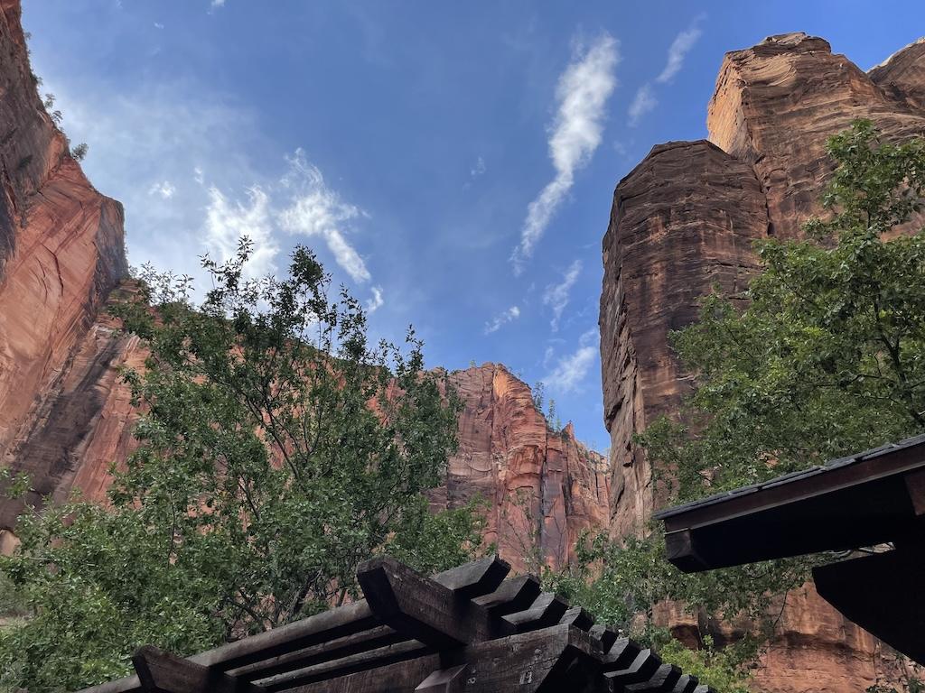 View of tall red rock mountains at the bus waiting area at bus stop 9 at Zion National Park in Utah