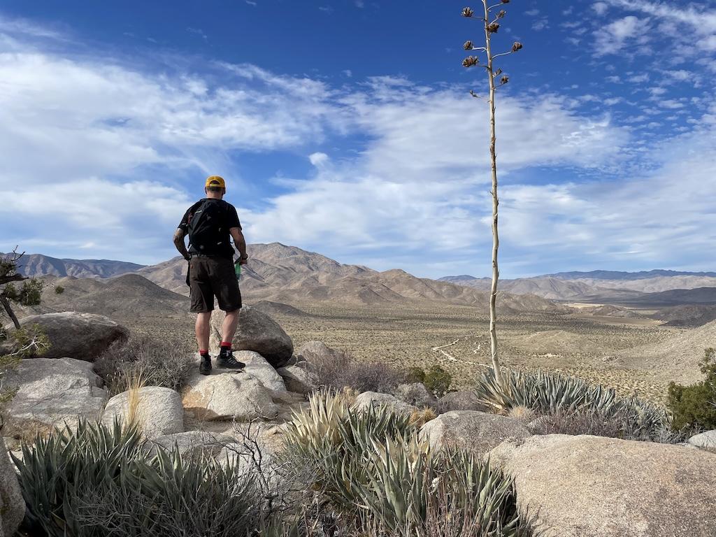 Man looking at the views of mountains in the distance at the summit of Ghost Mountain in Anza-Borrego Desert State Park, California