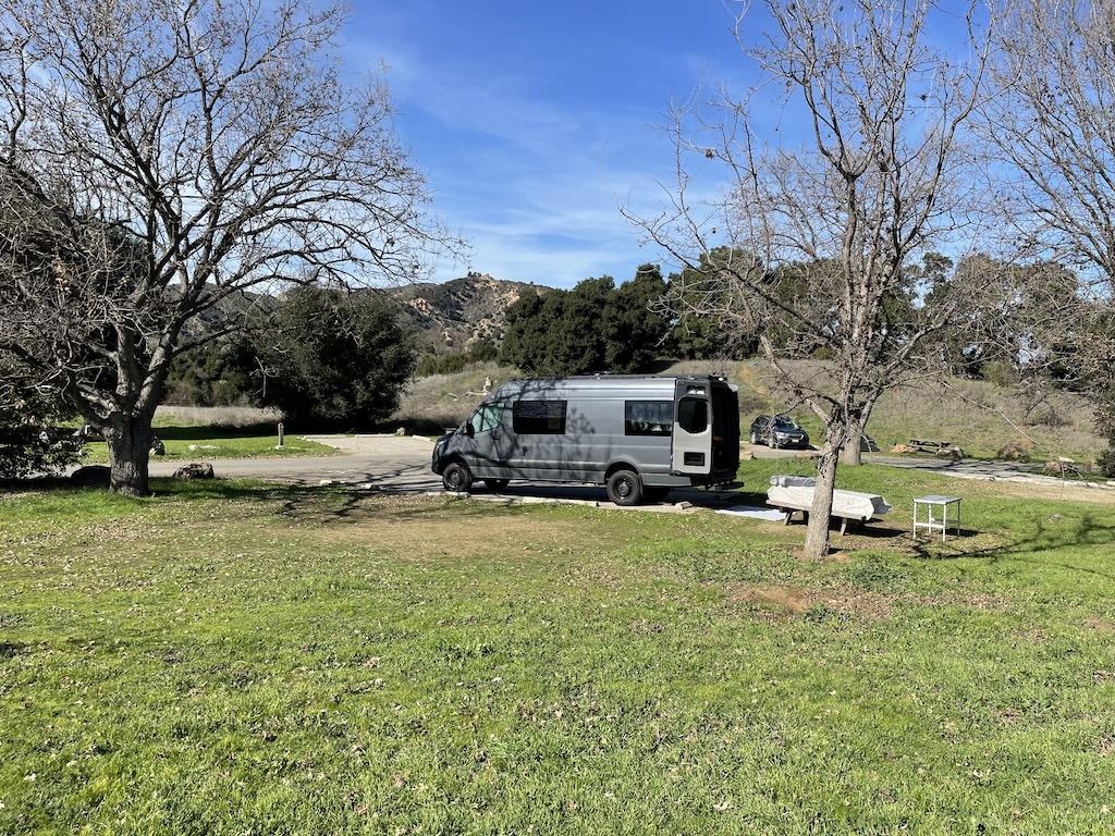 View of Luna’s sprinter camper van at Malibu Creek State Park in California, parked by the grass