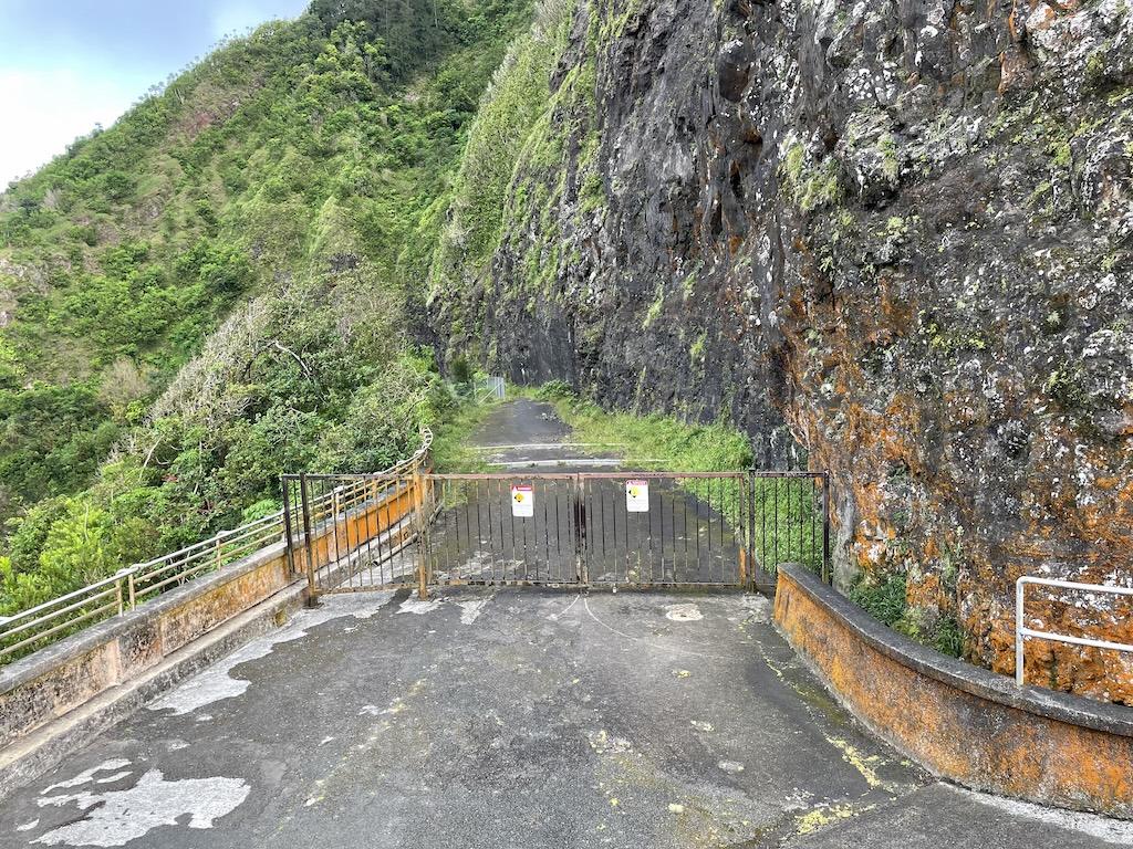 View of gate and old trail on the side of a mountain at Nu’uanu Pali Lookout, in Oahu, Hawaii 
