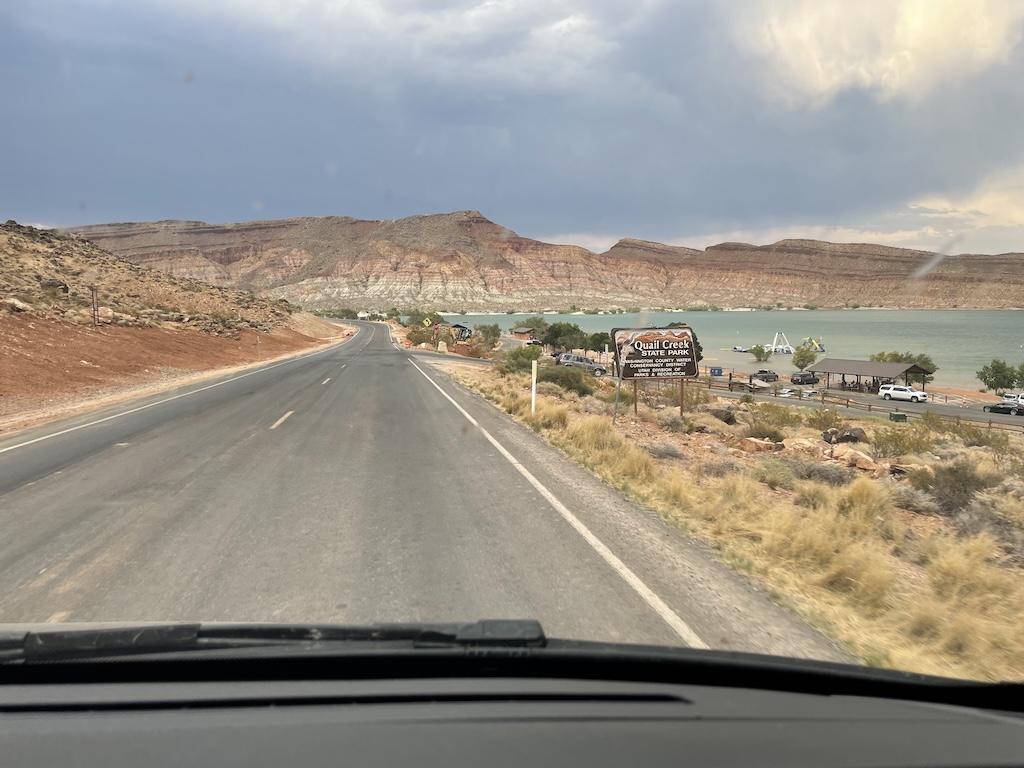 View of Quail Creek State Park sign from inside Luna’s camper van while driving to the campground in Utah