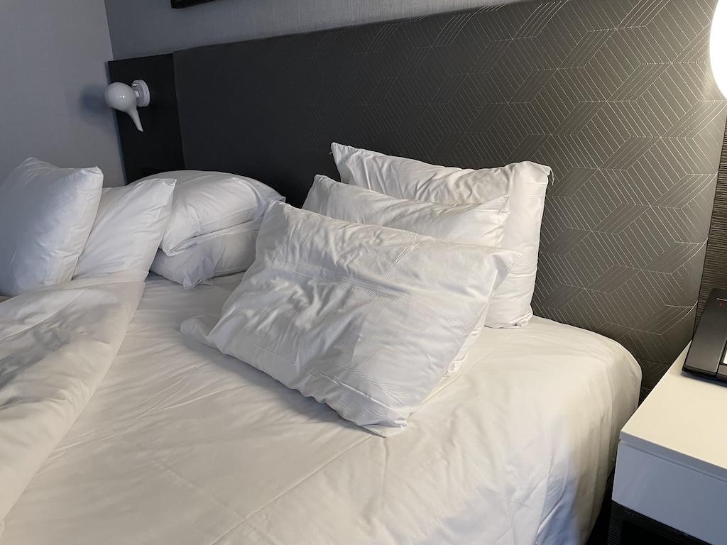 Pillows on bed in a hotel room where Luna stayed while traveling.