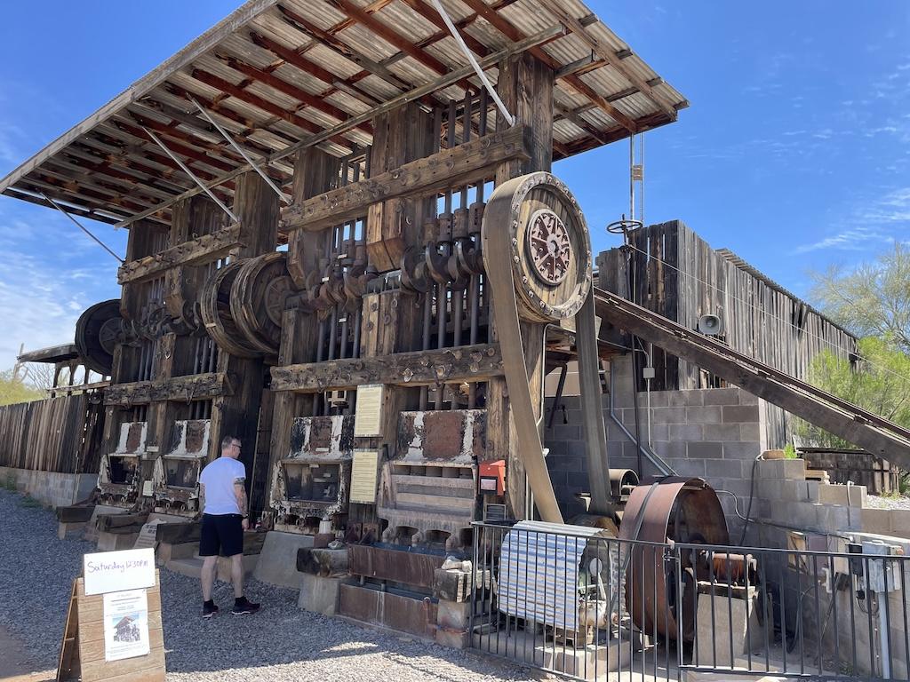 Man looking at the stamp ore mill at the Superstition Mountain Museum in Arizona