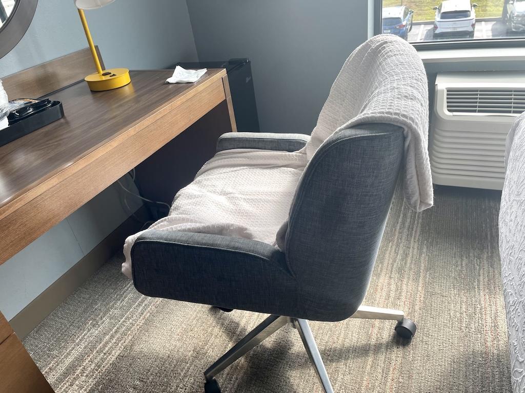 Chair with comforter on it in hotel room that Luna stayed at in the Midwest