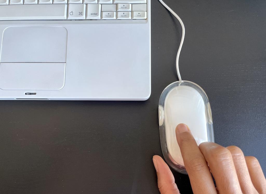Luna’s fingers on the old mouse that goes with her iBook G4 Apple laptop