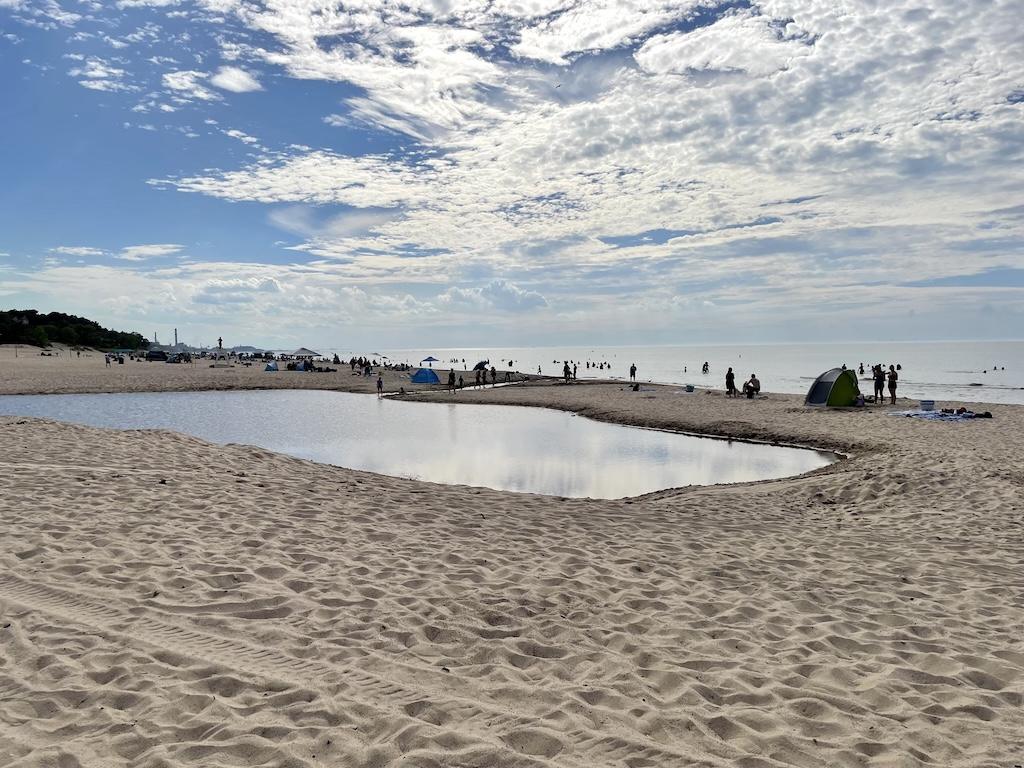 View of people at the beach in distance at Indiana Dunes State Park while approaching evening