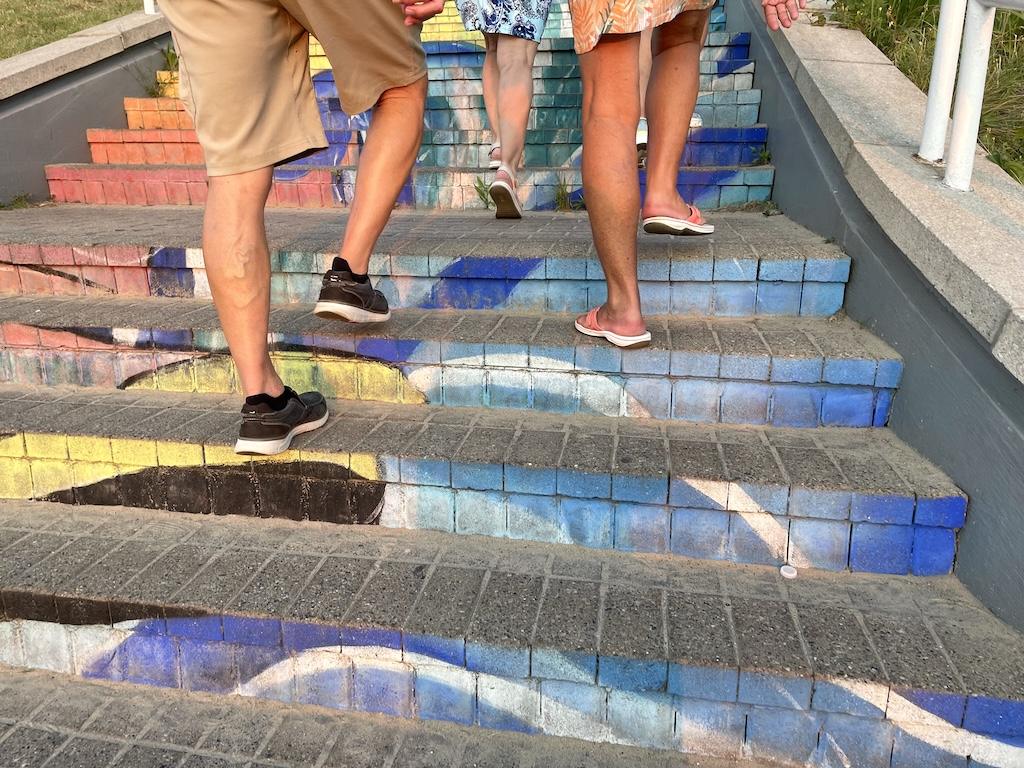 View of people’s feet walking up colored stairs at Silver Beach County Park in St. Joseph, Michigan.