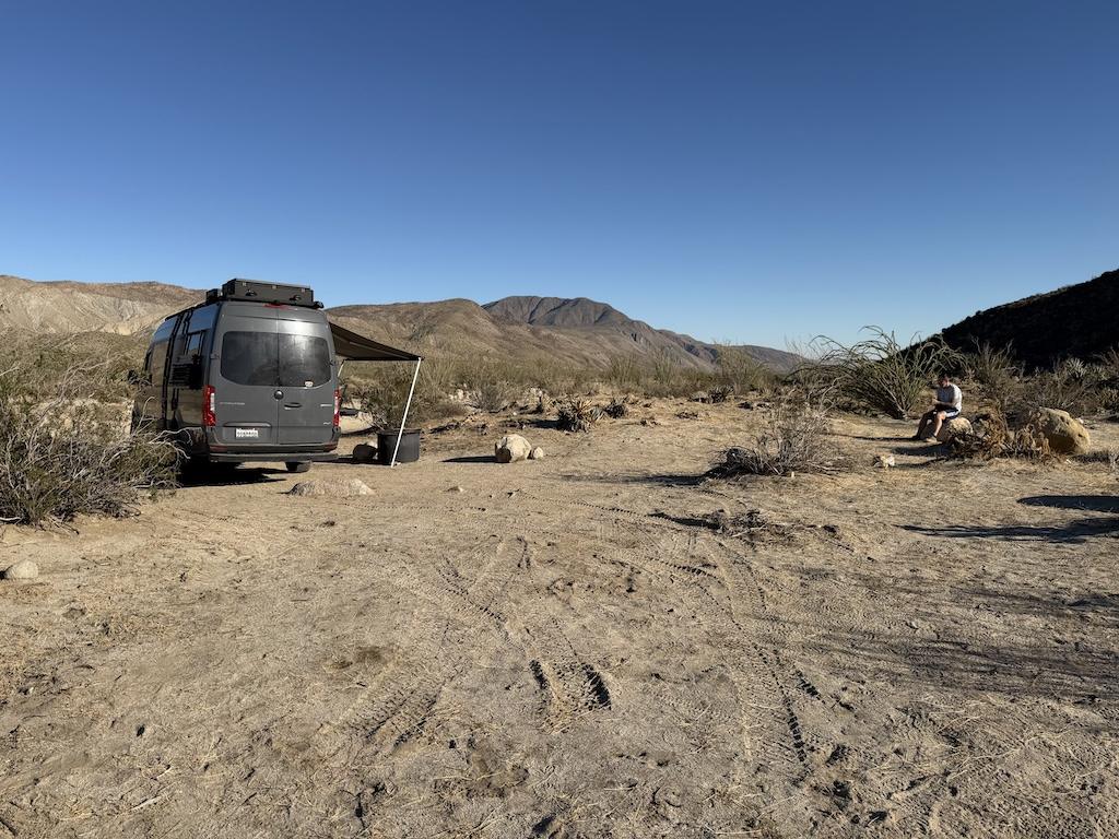 Man looking at Sprinter van parked off Coyote Canyon Road, at Anza-Borrego Desert State Park, California.