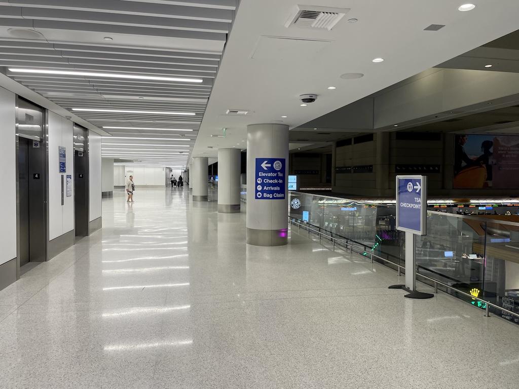 View of hallway with TSA checkpoint sign pointing to right, at LAX airport, California