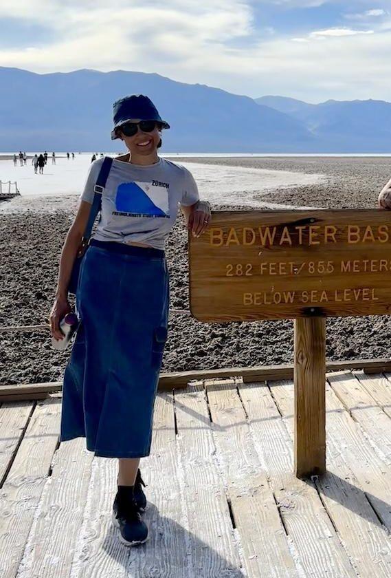 Luna smiling to the camera at Badwater Basin sign at Death Valley National Park, California