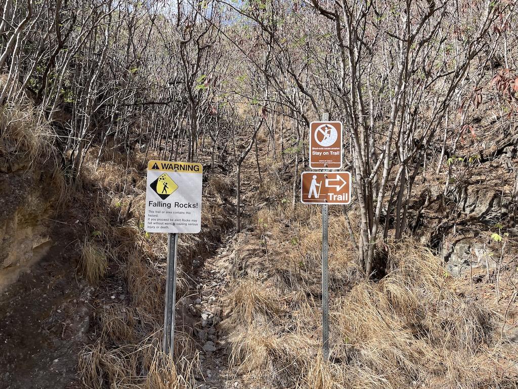 Signs at Diamond Head Crater to stay on trail and beware of falling rocks, Oahu, Hawaii