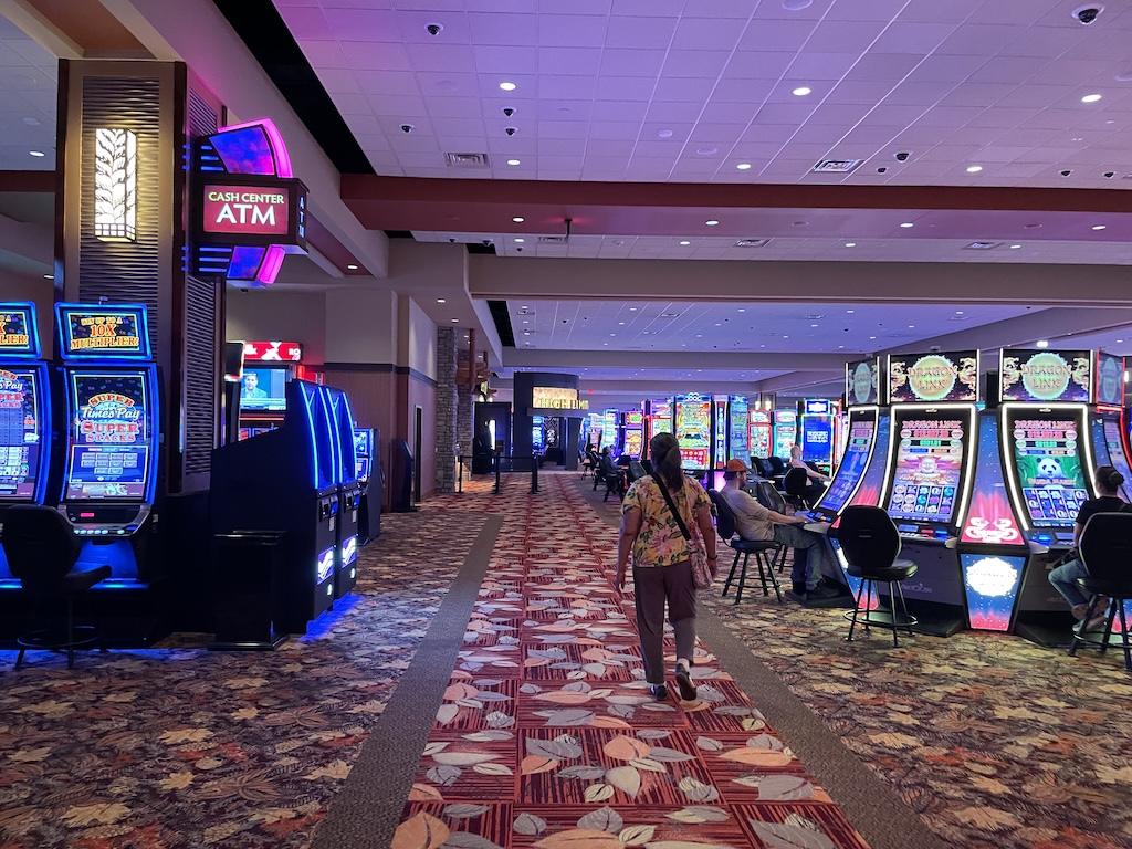 Slot machines at Four Winds Casino South Bend, Indiana showing lady walking at gaming floor