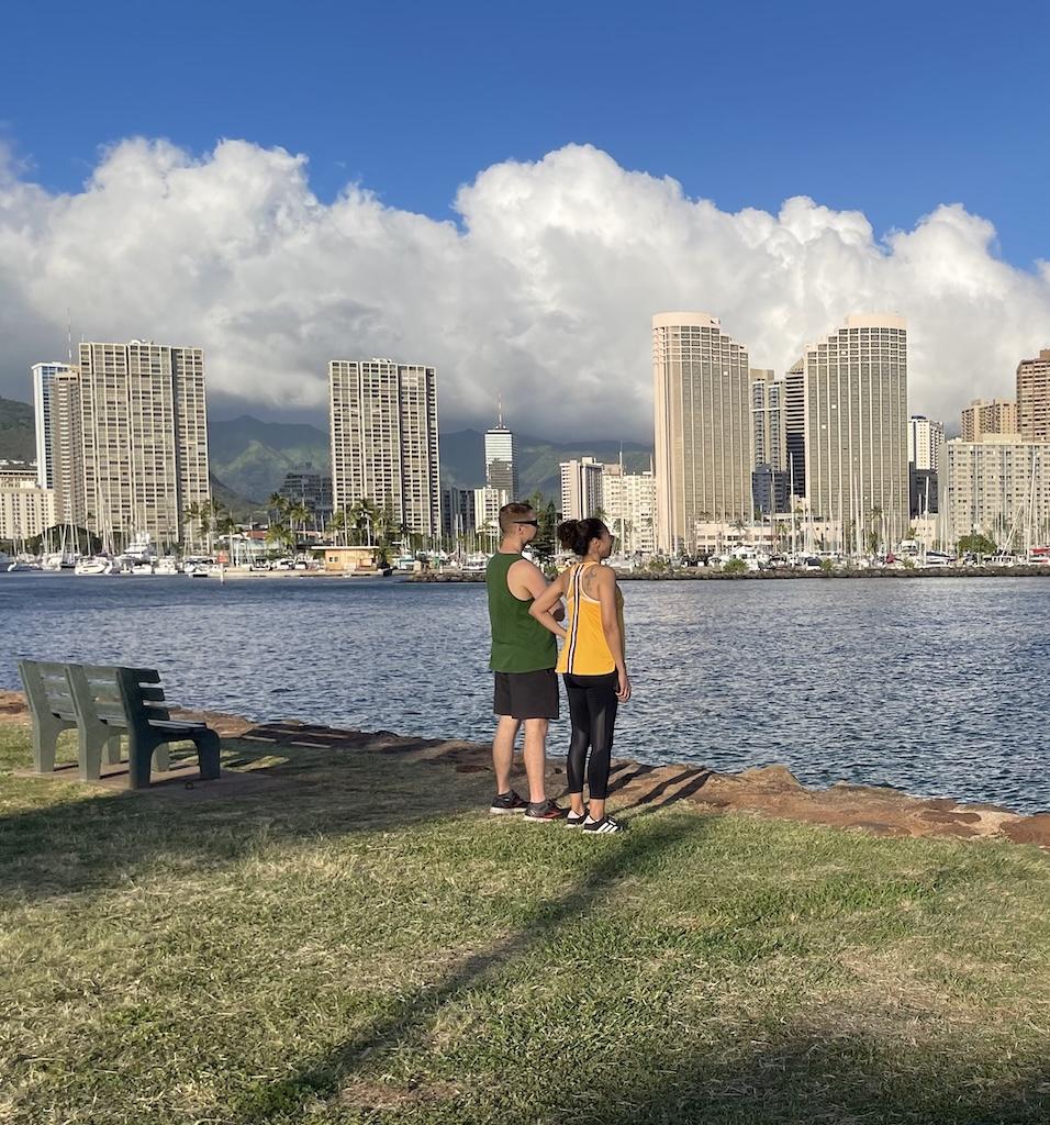 People standing by the water looking at building in Waikiki, Hawaii