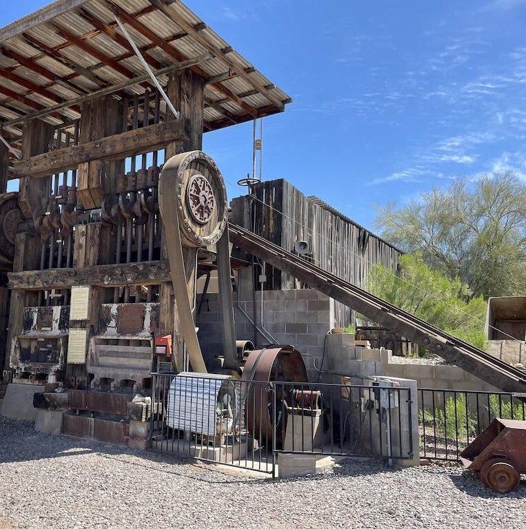 Man looking at the stamp ore mill at the Superstition Mountain Museum in Arizona