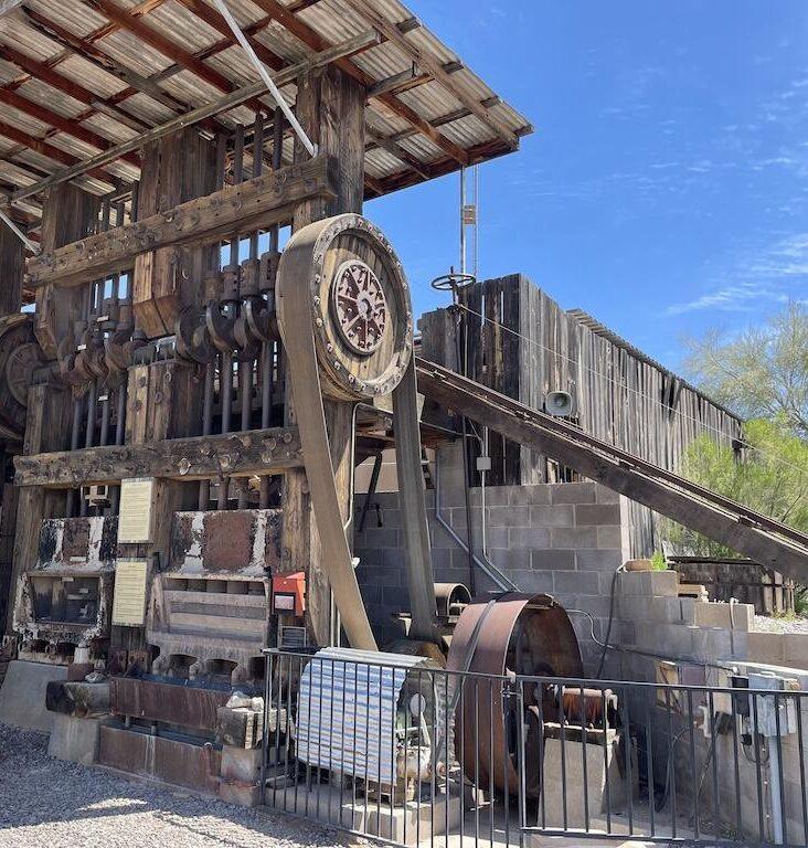 Man looking at the stamp ore mill at the Superstition Mountain Museum in Arizona